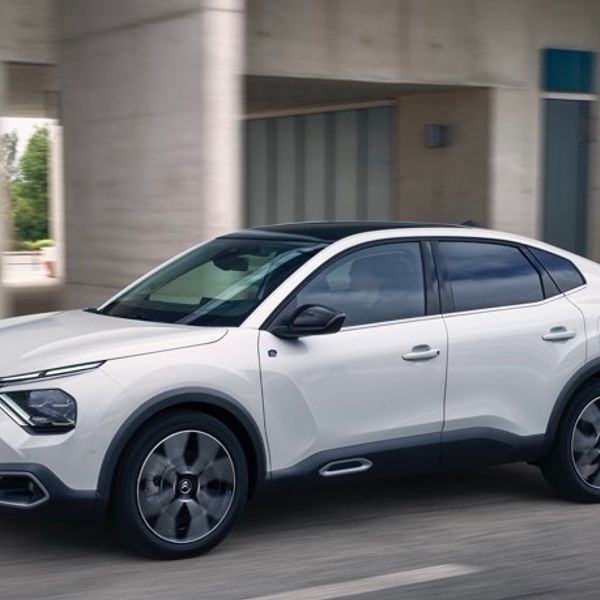 White Citroen e-C4X side profile view while driving